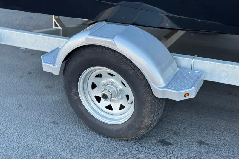 Slide: The Image of Trailer wheel and fender of 2023 Bayliner DX 2050 boat on pavement. - 30