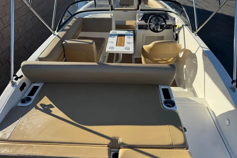 Slide: The Image of 2023 Bayliner DX 2050 boat interior with tan seating and steering wheel. - 8