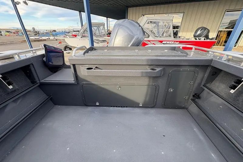 Slide: The Image of Interior view of 2026 Weldcraft 210 Revolution HT boat, showcasing storage compartments and seating area. - 22