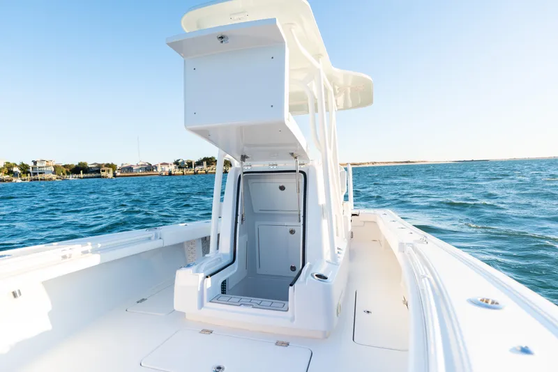 Slide: The Image of 2020 BARKER 26 boat on open water, showcasing spacious deck and storage. - 20