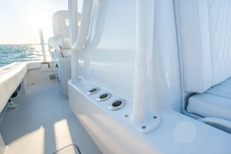 Slide: The Image of Interior view of a 2020 BARKER 26 boat with white seating and rod holders. - 21