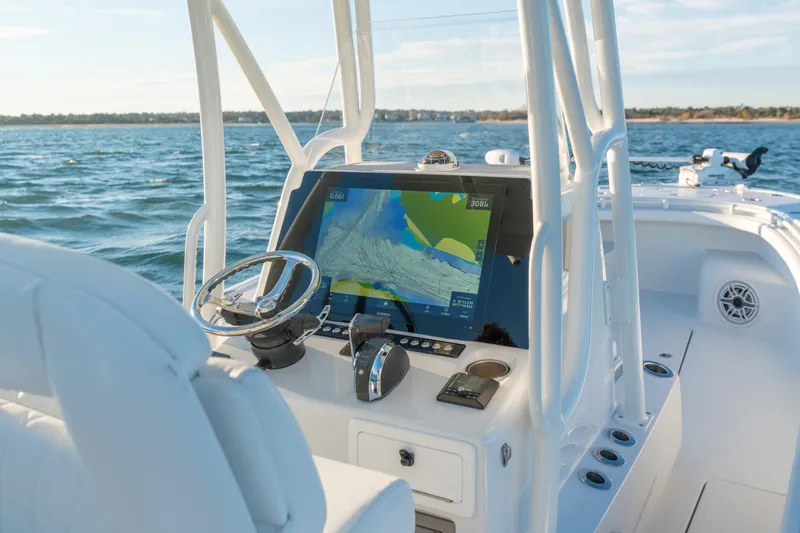 Slide: The Image of 2020 BARKER 26 boat dashboard with navigation screen on open water. - 27