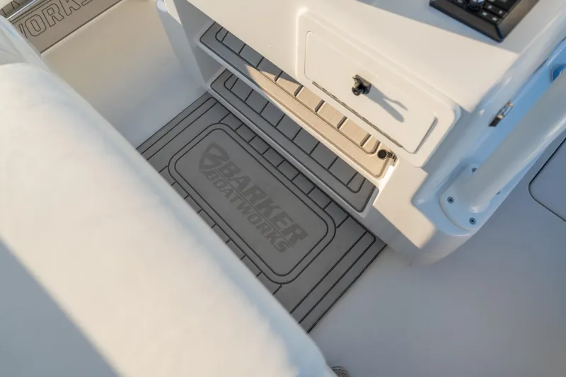 Slide: The Image of BARKER 26 boat interior, featuring storage compartment and branded mat, 2020 model. - 34