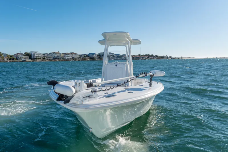 Slide: The Image of 2020 BARKER 26 boat cruising on a sunny day near coastal homes. - 7