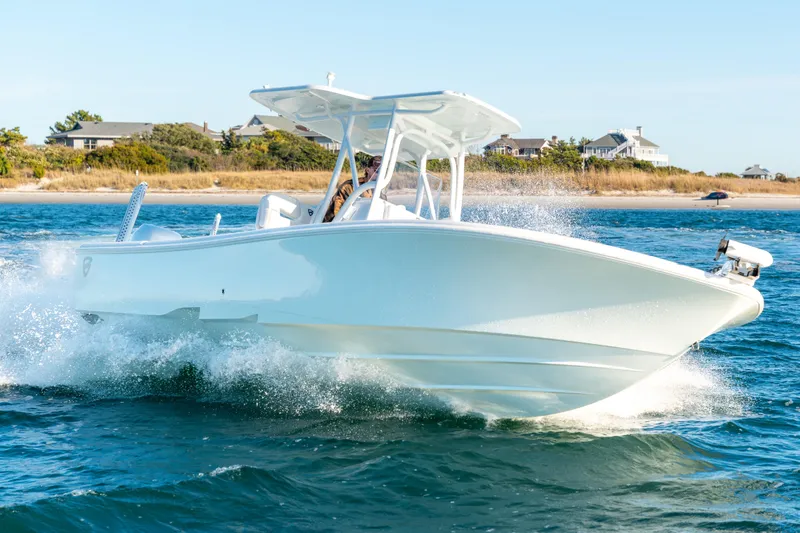 Slide: The Image of 2020 BARKER 26 boat cruising on water near a coastal landscape. - 9