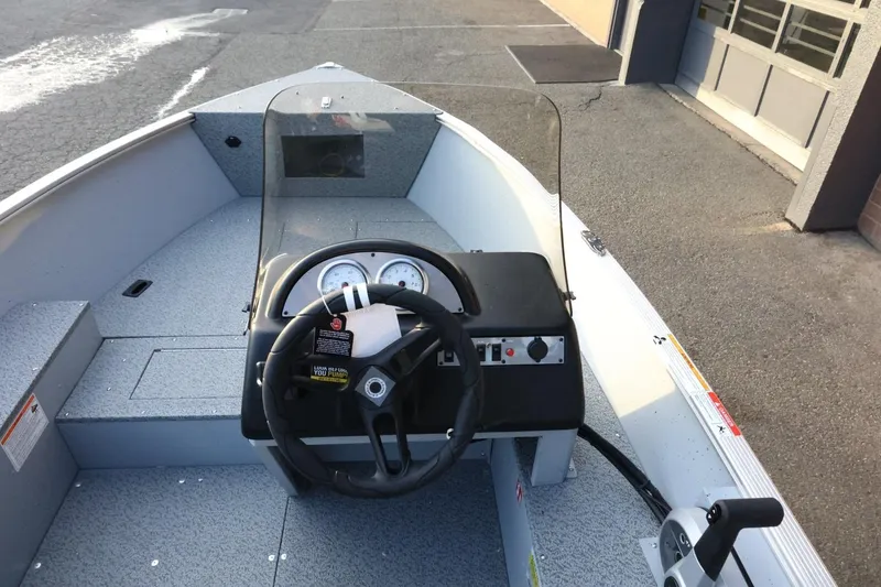 Slide: The Image of 2026 Lund 1600 Fury SS boat interior with steering wheel and dashboard controls. - 10
