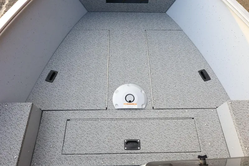 Slide: The Image of 2026 Lund 1600 Fury SS boat interior with gray textured flooring and storage compartments. - 11