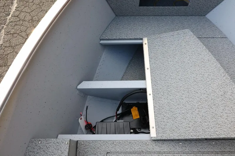 Slide: The Image of 2026 Lund 1600 Fury SS boat interior with storage compartment and wiring visible. - 13