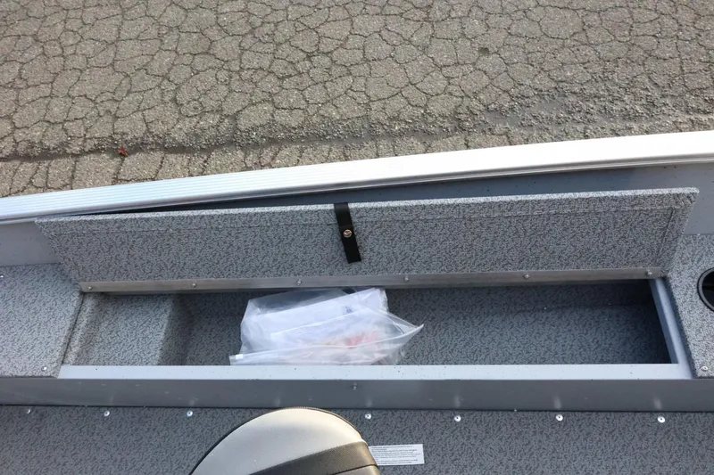 Slide: The Image of 2026 Lund 1600 Fury SS boat storage compartment with textured interior and secure latch. - 16