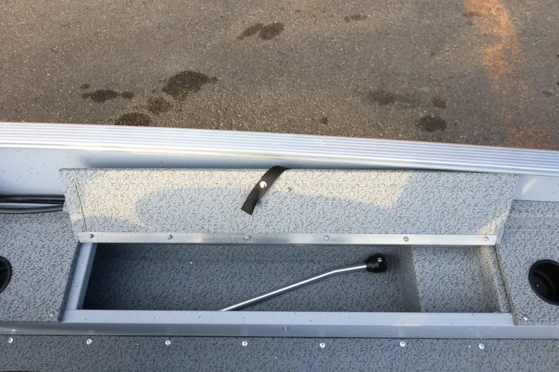 Slide: The Image of 2026 Lund 1600 Fury SS boat interior with storage compartment and lever. - 17