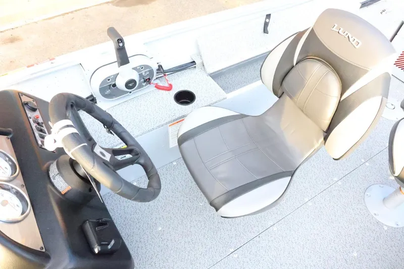 Slide: The Image of 2026 Lund 1600 Fury SS boat interior with steering wheel and comfortable seating. - 25