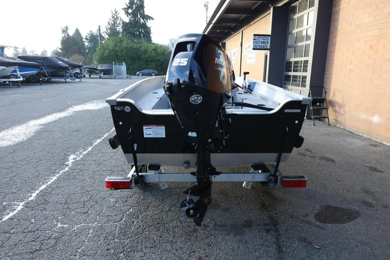 Slide: The Image of 2026 Lund 1600 Fury SS boat with Mercury 25 HP engine, parked outdoors. - 7