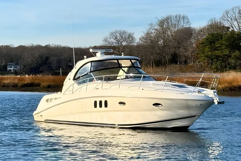 The Image of 2008 Sea Ray 38 Sundancer yacht on calm water, surrounded by trees. - 0