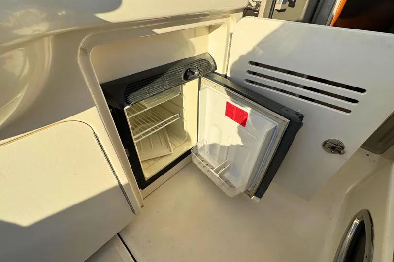Slide: The Image of Open mini fridge on 2008 Sea Ray 38 Sundancer boat, showing interior shelves. - 11