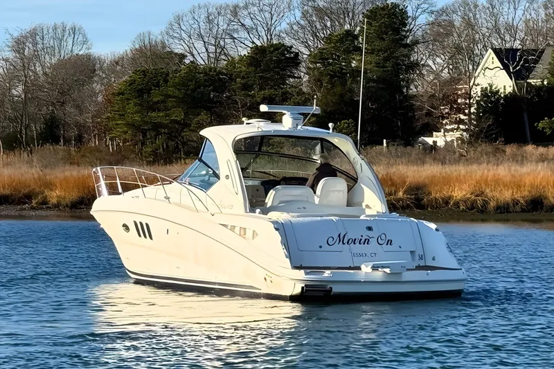 Slide: The Image of 2008 Sea Ray 38 Sundancer yacht on calm water near shoreline. - 2