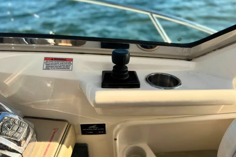 Slide: The Image of 2008 Sea Ray 38 Sundancer helm with joystick control and cup holder, overlooking water. - 21