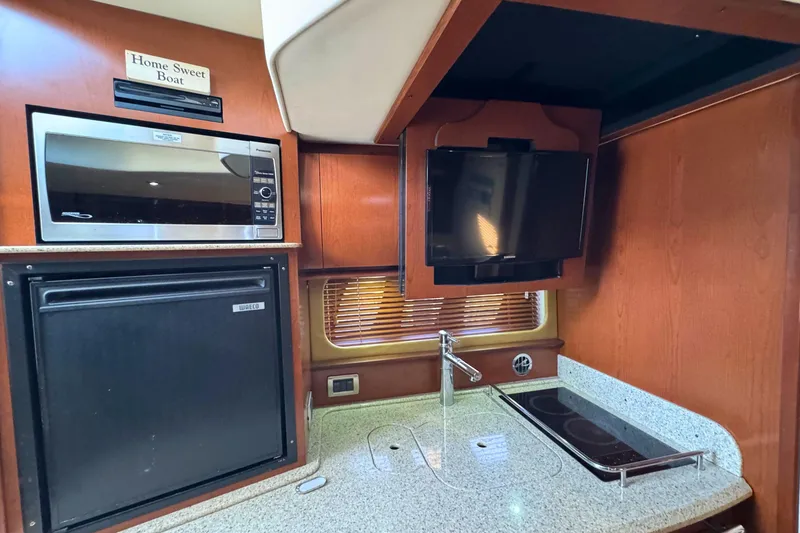 Slide: The Image of 2008 Sea Ray 38 Sundancer kitchen with microwave, fridge, TV, and stove. - 29