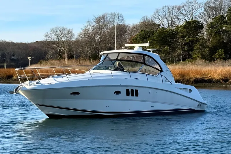 Slide: The Image of 2008 Sea Ray 38 Sundancer yacht on calm water, surrounded by trees. - 3