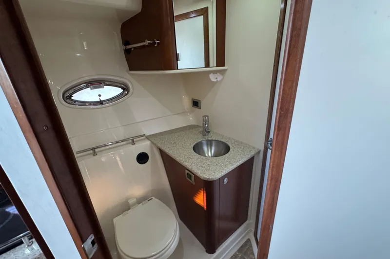 Slide: The Image of 2008 Sea Ray 38 Sundancer bathroom with sink, toilet, and porthole window. - 39