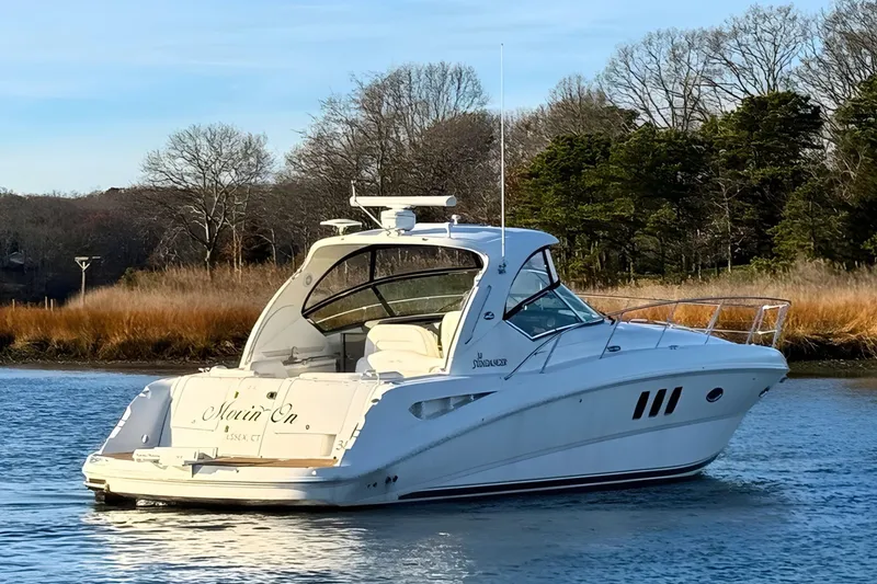 Slide: The Image of 2008 Sea Ray 38 Sundancer yacht on calm water, surrounded by trees. - 4