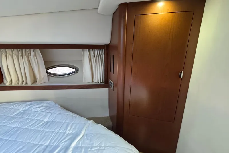 Slide: The Image of Interior cabin of 2008 Sea Ray 38 Sundancer with wood paneling and porthole window. - 43