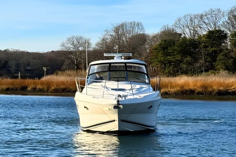Slide: The Image of 2008 Sea Ray 38 Sundancer yacht cruising on a serene river with trees in the background. - 6