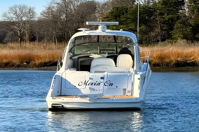 Slide: The Image of 2008 Sea Ray 38 Sundancer yacht on calm water, rear view, surrounded by trees. - 7