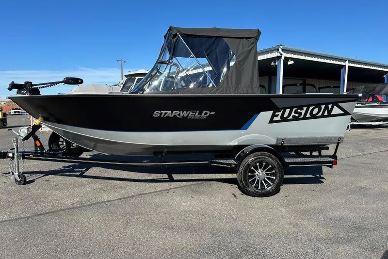 The Image of 2025 Starweld Fusion Pro 20 DC boat on trailer, black and silver design. - 0