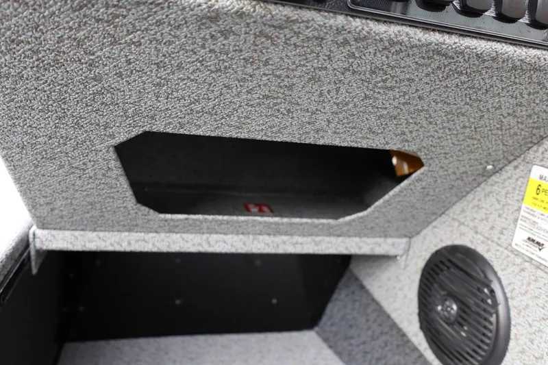 Slide: The Image of Interior view of 2026 Lund 1775 Adventure Sport boat, featuring storage compartment and speaker. - 27