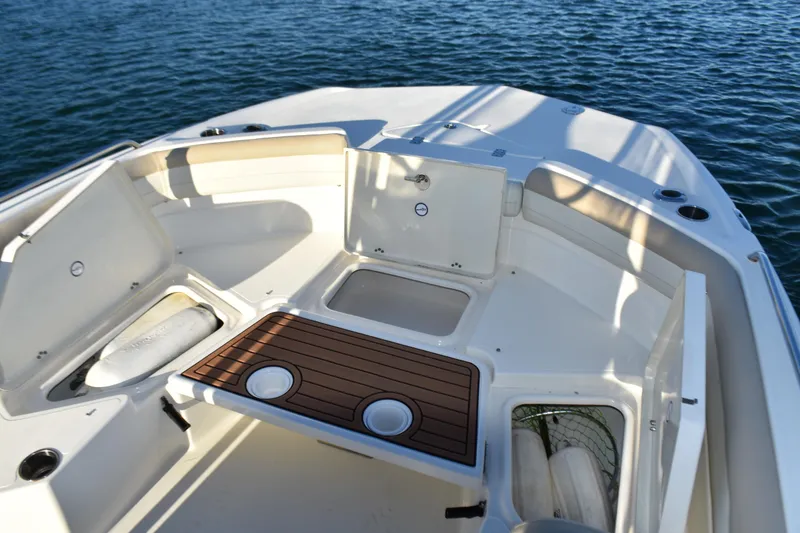 Slide: The Image of 2017 NauticStar 231 Angler boat interior with storage compartments and seating on the water. - 11