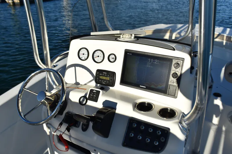 Slide: The Image of 2017 NauticStar 231 Angler boat dashboard with steering wheel and navigation instruments. - 16