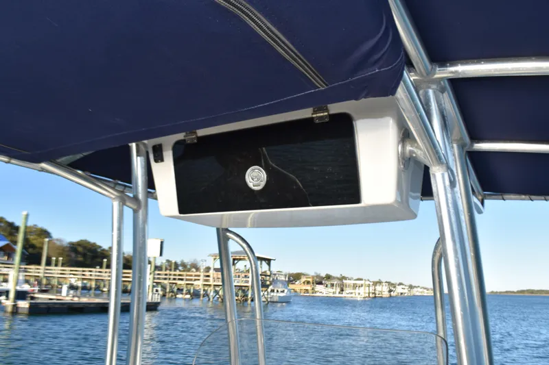 Slide: The Image of 2017 NauticStar 231 Angler boat with T-top and storage compartment, dockside view. - 17