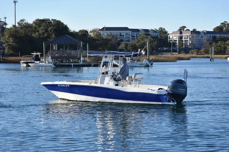 Slide: The Image of 2017 NauticStar 231 Angler boat on calm water, with Yamaha outboard motor. - 5