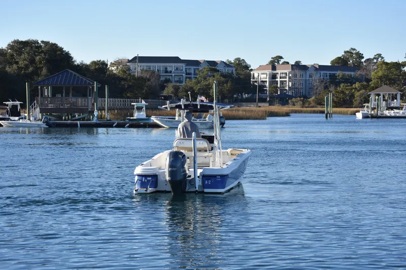 Slide: The Image of 2017 NauticStar 231 Angler boat cruising near waterfront homes and docks. - 7