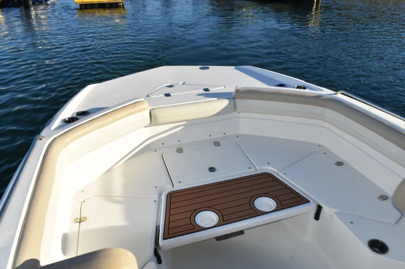 Slide: The Image of 2017 NauticStar 231 Angler boat interior with seating and storage, docked on calm water. - 8