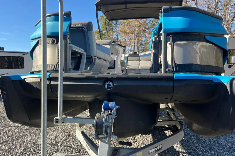 Slide: The Image of 2023 Sea-Doo Switch Cruise 21 pontoon boat on trailer, blue and black design. - 5