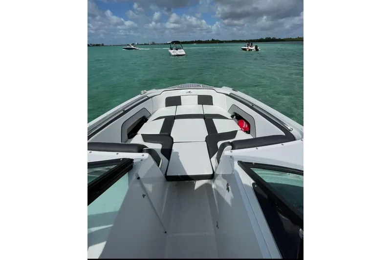 Slide: The Image of 2022 Monterey M-65 boat interior with cushioned seating on turquoise water. - 4