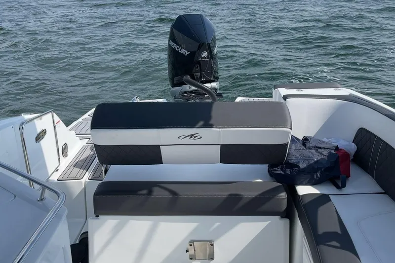 Slide: The Image of 2022 Monterey M-65 boat interior with seating and canopy, docked under clear blue sky. - 5