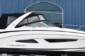 The Image of 2015 Regal 32 Express boat with sleek design, docked near a blue building. - 0