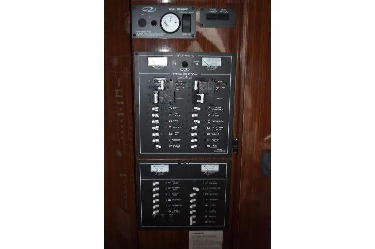 Slide: The Image of Electrical control panel of 2015 Regal 32 Express boat, featuring switches and gauges. - 17