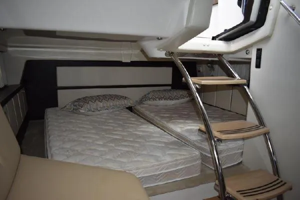 Slide: The Image of 2015 Regal 32 Express cabin with twin beds and wooden ladder. - 18