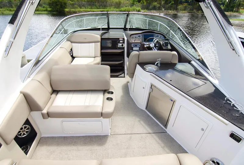 Slide: The Image of 2015 Regal 32 Express boat on trailer, parked near road, clear sky background. - 3