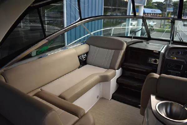 Slide: The Image of 2015 Regal 32 Express boat interior with beige seating and modern dashboard. - 7