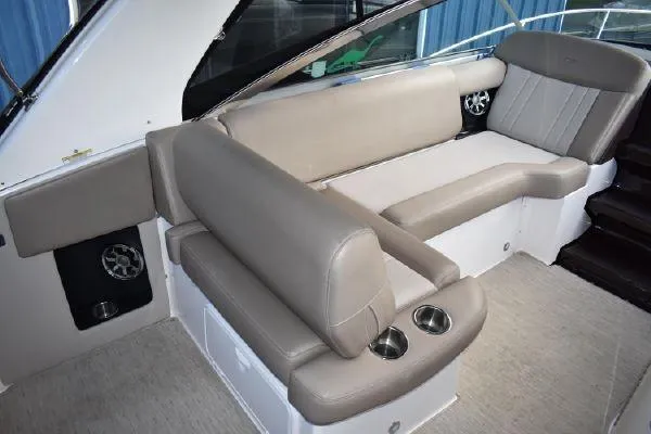Slide: The Image of 2015 Regal 32 Express boat interior with beige seating and cup holders. - 8