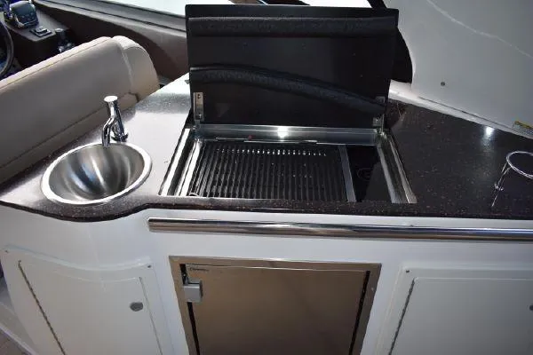 Slide: The Image of 2015 Regal 32 Express boat kitchenette with sink and grill. - 9