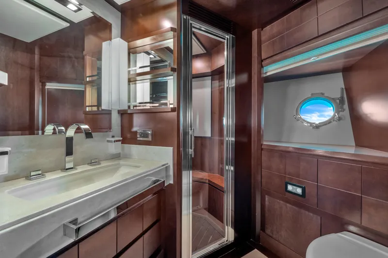 Slide: The Image of Luxurious bathroom interior on 2010 Azimut 95 yacht, featuring modern fixtures and porthole view. - 19