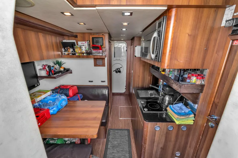 Slide: The Image of Interior of 2010 Azimut 95 yacht featuring a compact kitchen and dining area. - 23