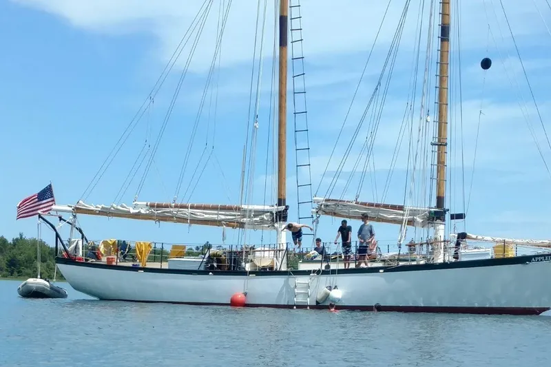 Slide: The Image of Sailing schooner Treworgy 65 Schooner 1992 on calm water with crew and American flag. - 12