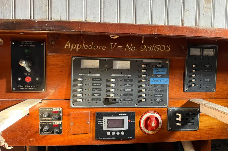 Slide: The Image of Control panel of 1992 Treworgy 65 Schooner, featuring switches and gauges. - 13