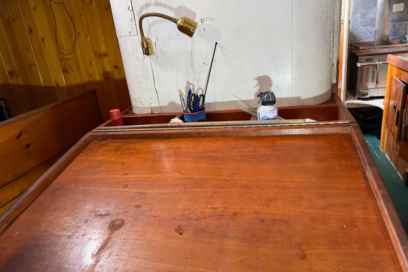 Slide: The Image of Wooden interior of 1992 Treworgy 65 Schooner with desk, lamp, and storage. - 15